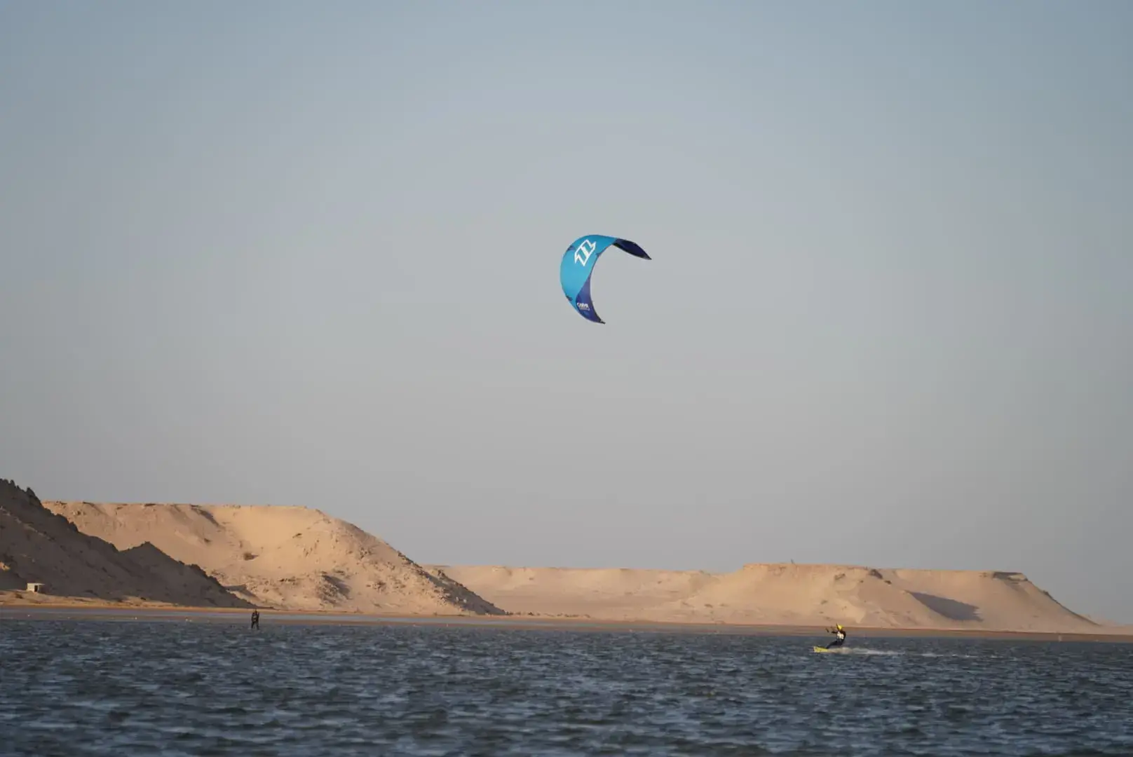 Colorful kite flying high above the waters of Dakhla, Morocco