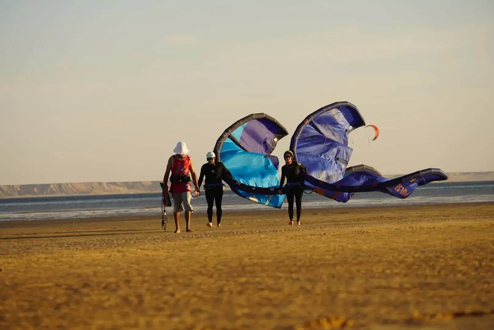 Kitesurfer walking into the water with a kite in Dakhla, Morocco